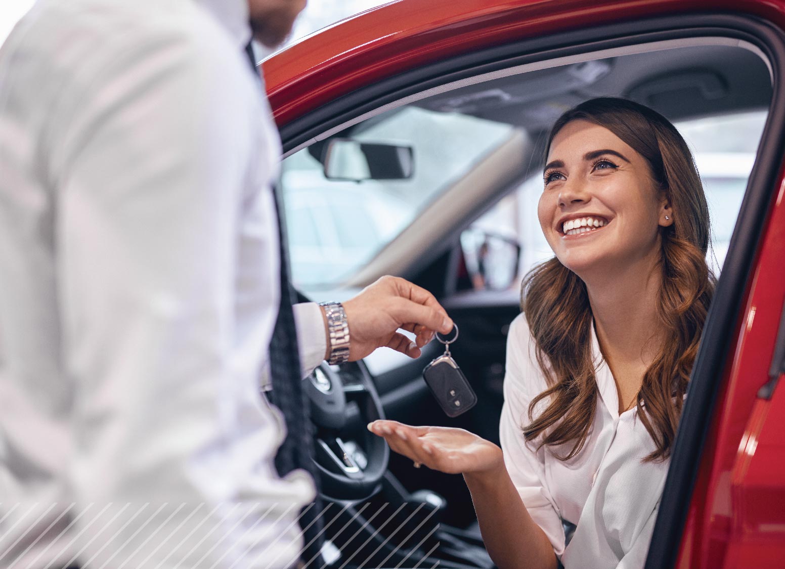 Happy woman receiving car keys after securing a low-rate auto loan.