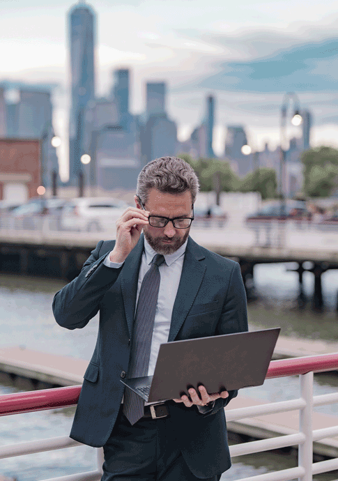 Professional managing finances with Business Online Banking on a laptop while outdoors.