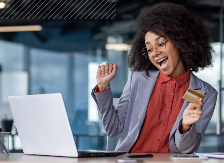 Professional woman holding card while sitting at a computer