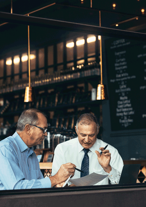 Two men in a coffee shop discussing business