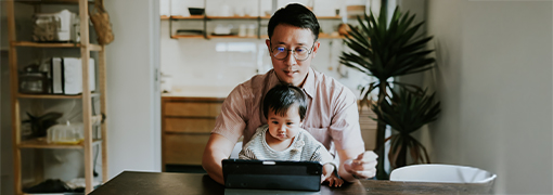 Father using a tablet at home, managing his finances online.