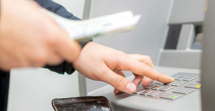 Image of customers using FSB's ATM to deposit funds.