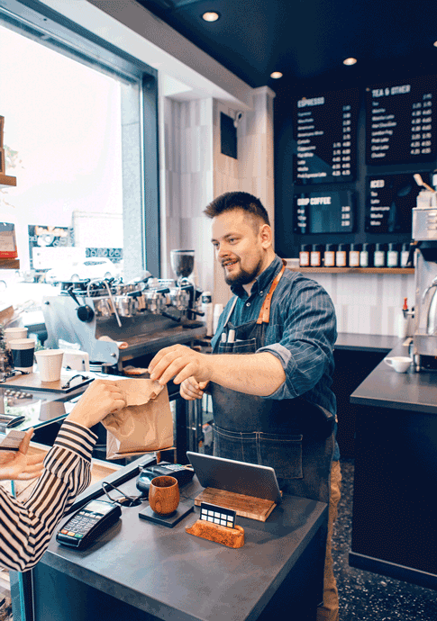 Small business owner serving a customer at a coffee shop in Cedar Rapids, IA.